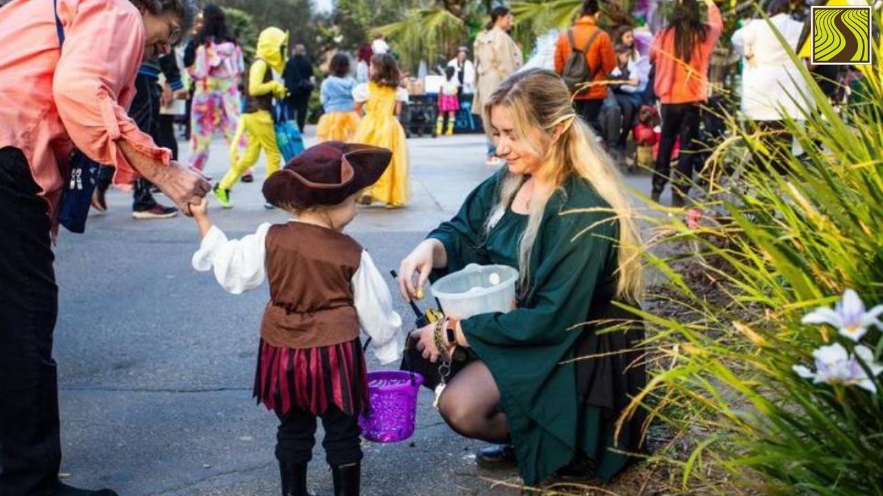 Child in pirate costume trick-or-treating, adult with elf ears handing out candy.
