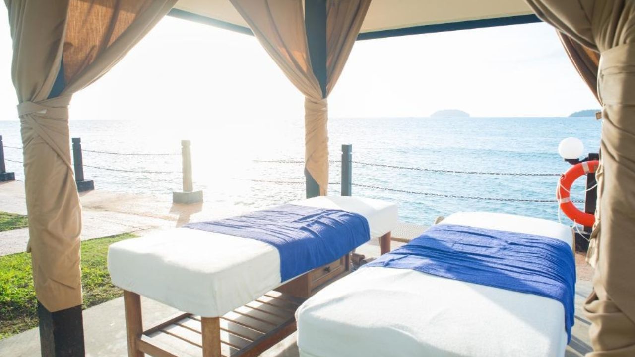 Outdoor spa with two massage tables overlooking ocean views.