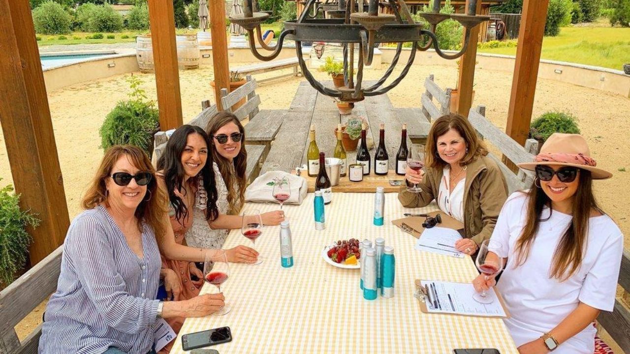 Group enjoying wine tasting with notes during corporate vineyard tour.
