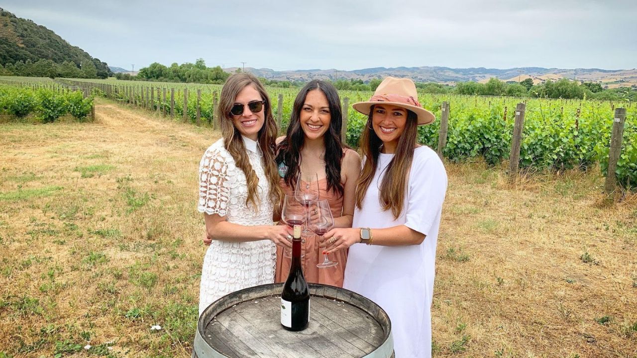 Guests tasting wine outdoors at boutique vineyard estate.