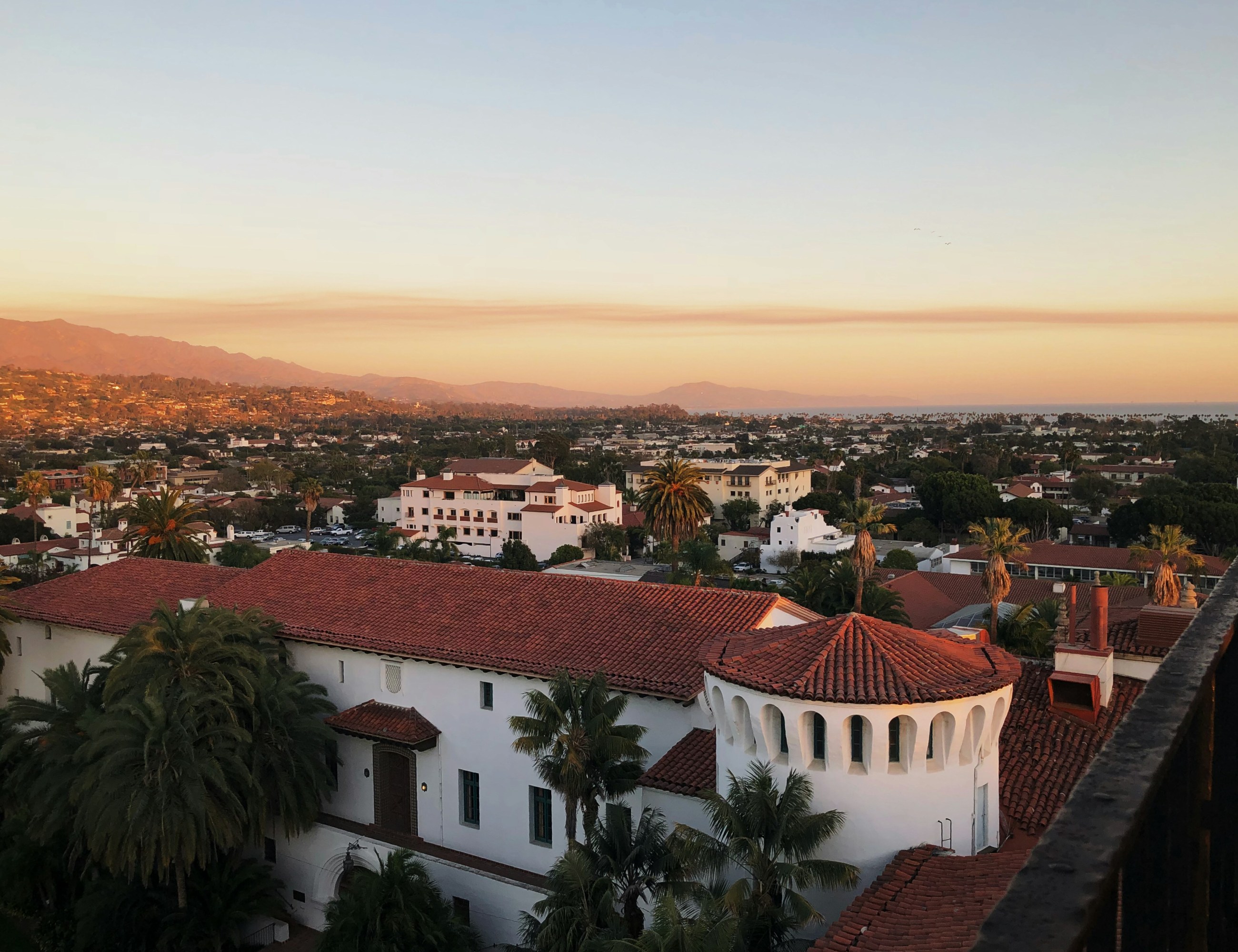 Santa Barbara coastal cityscape with Spanish-style architecture at sunset.