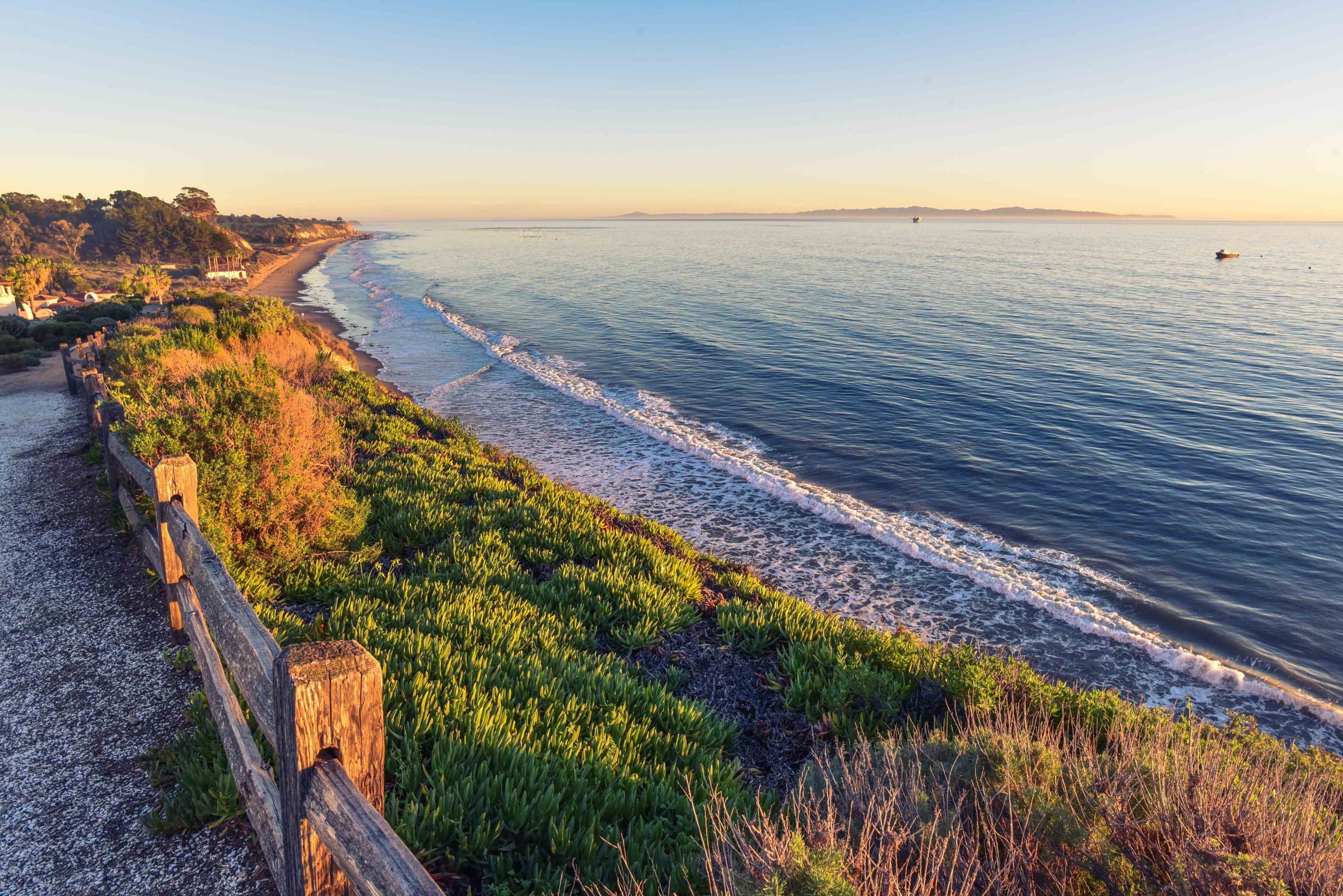 Santa Barbara coastline view with beach, cliffs, and golden sky.