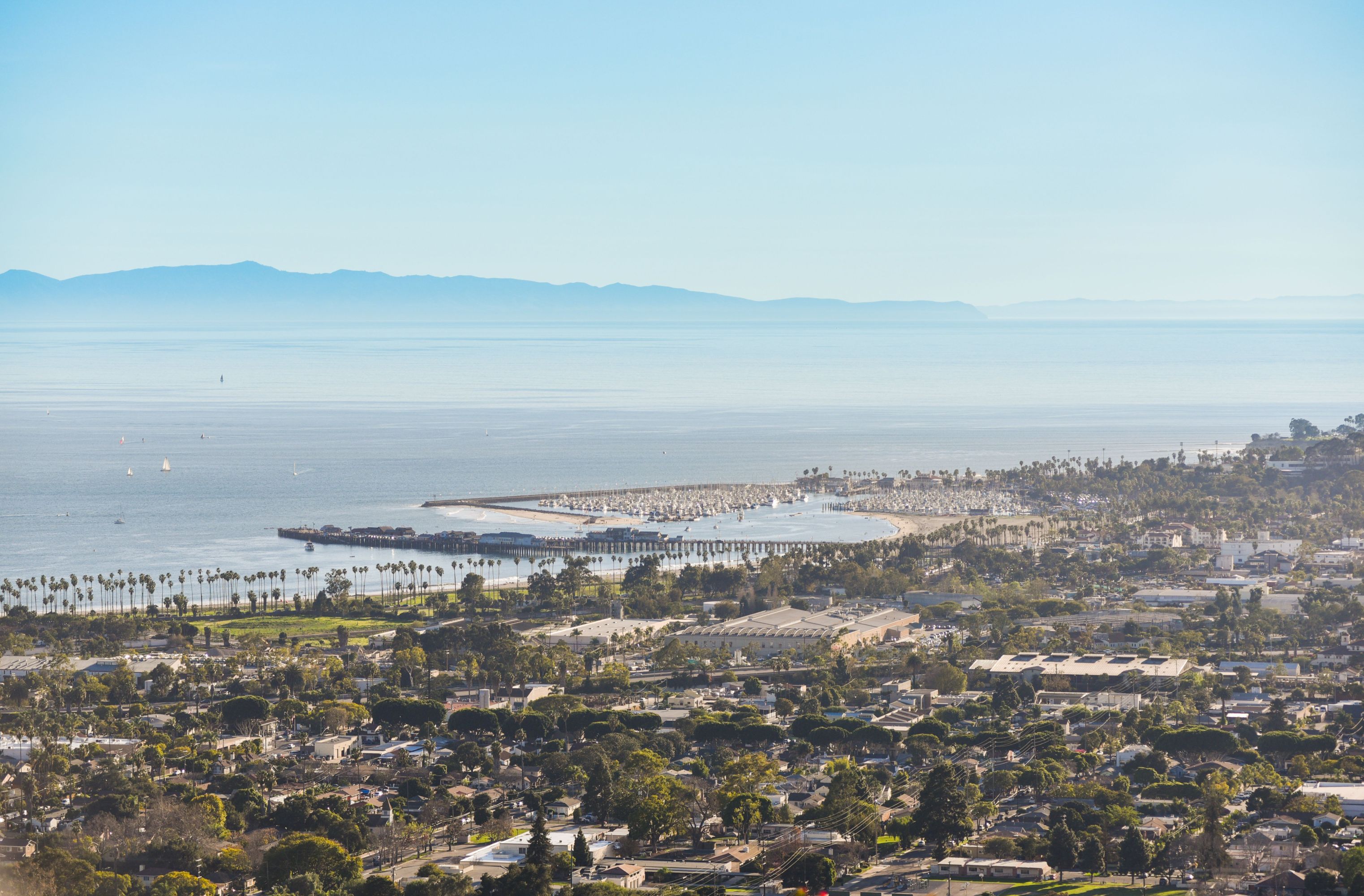 Santa Barbara marina with boats, palm trees, and mountains.