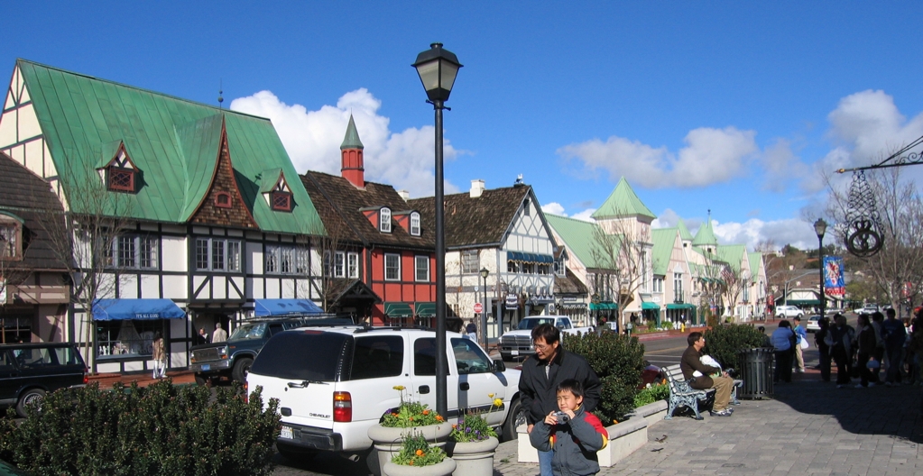 Solvang street with Danish architecture, shops, and sunny sky.
